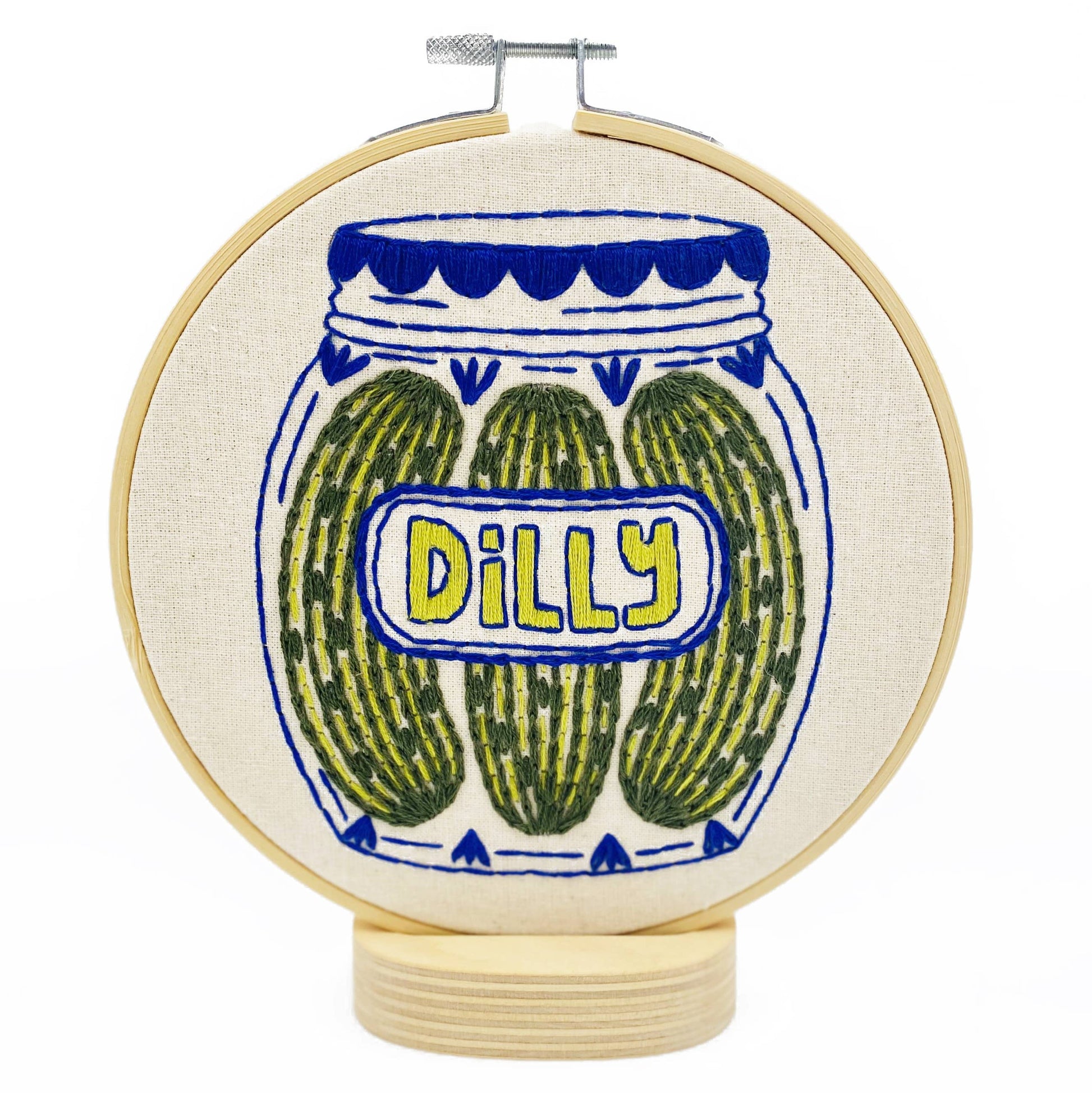 Embroidery hoop with a jar of pickles design and 'Dilly' text on a white background