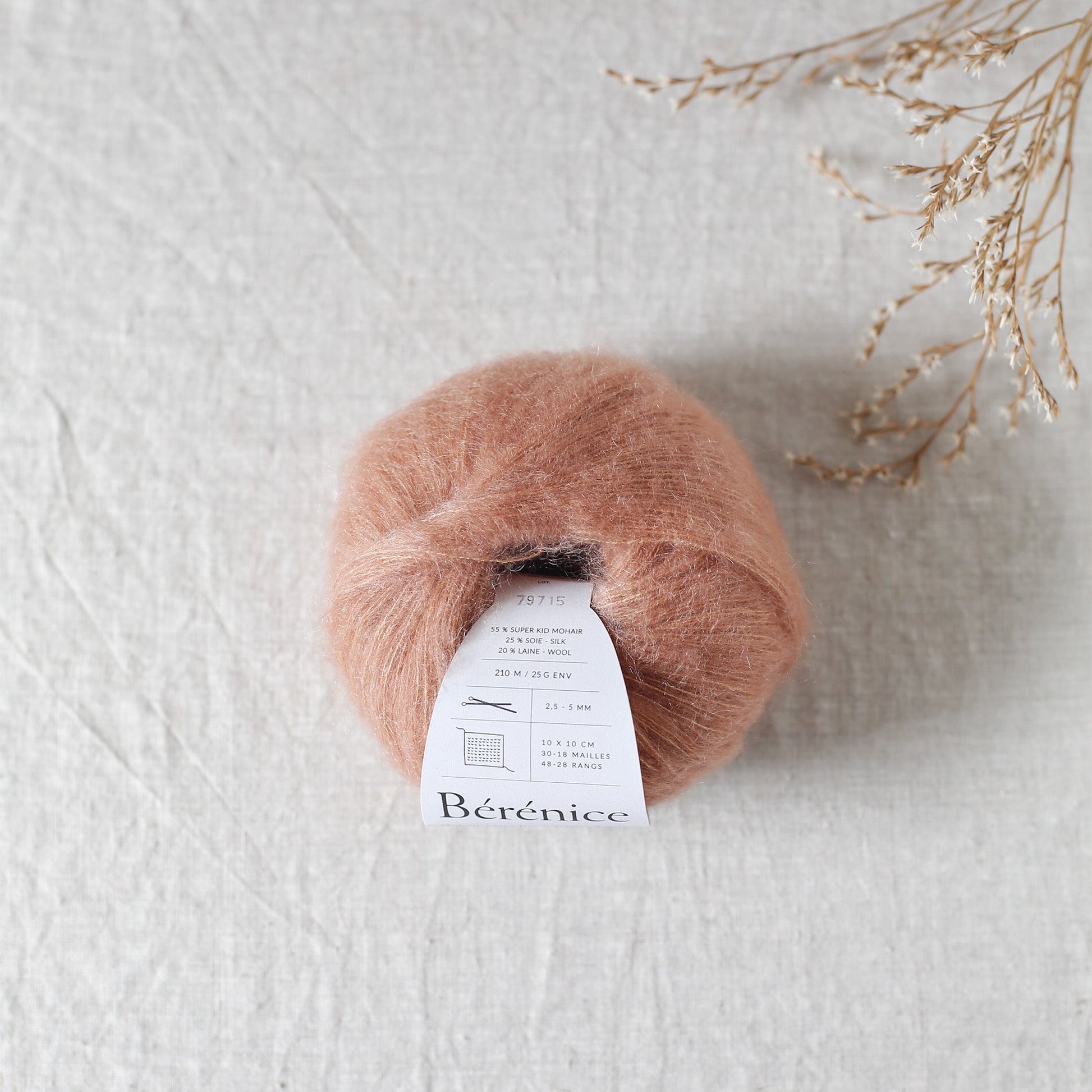 Ball of pink yarn with a label on a light gray background